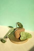 Jade Gua sha scraper and facial massager on beige background. Lifting and toning treatment at home. photo