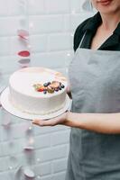 un hermosa mousse pastel en el manos de un Pastelería cocinero foto