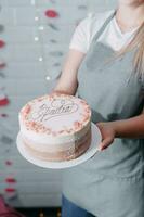 un hermosa mousse pastel en el manos de un Pastelería cocinero foto