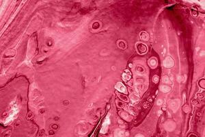 Spread-out acrylic paint. Abstract background, made in the technique of fluid art. Demonstrating the colors of 2023 - Viva Magenta photo