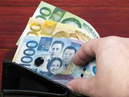 filipino dinero - peso en el negro billetera foto