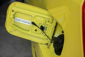 selective focus on the yellow car fuel tank cover with a warning using octane fuel number 92. soft focus photo