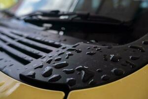 selective focus to water droplets on car hood. soft focus photo