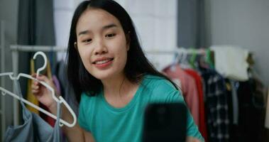 Aufnahmen schließen oben Schuss von jung schön asiatisch Frauen Leben Streaming zu Verkauf Neu Mode Kleider beim Zuhause Studio, Sie genießen zu reden im Vorderseite von Digital Kamera, Influencer auf Sozial Medien Konzept video