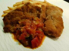 breaded wiener schnitzel with side dishes photo