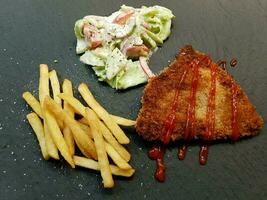 breaded wiener schnitzel with side dishes photo