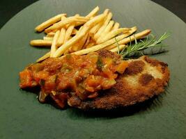 breaded wiener schnitzel with side dishes photo