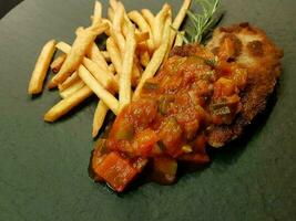 breaded wiener schnitzel with side dishes photo