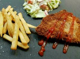 breaded wiener schnitzel with side dishes photo