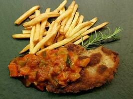 breaded wiener schnitzel with side dishes photo