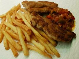 breaded wiener schnitzel with side dishes photo