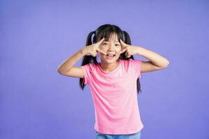 hermosa asiático niña retrato posando en púrpura antecedentes foto