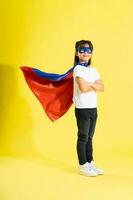 Portrait of little girl dressed up as a hero, isolated on yellow background photo