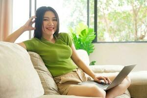 Portrait of a happy asian woman relaxing at home photo