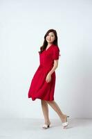 Portrait of a beautiful, charming lady wearing a red dress on a white background photo