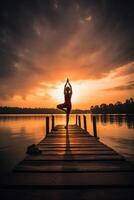 Serenity in Motion Woman Engaging in Sunset Yoga on Lake Pier photo