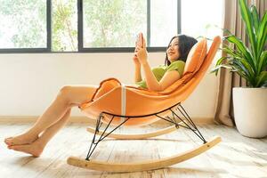 image of asian girl relaxing on a chair at her house photo