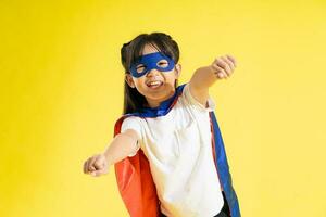 Portrait of little girl dressed up as a hero, isolated on yellow background photo