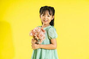 happy smiling asian girl on yellow background photo
