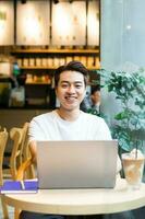 Asian man sitting at coffee shop photo