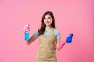 portrait of asian girl wearing apron on pink background photo