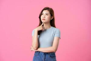 portrait of young asian girl posing on pink background photo