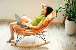 image of asian girl relaxing on a chair at her house photo