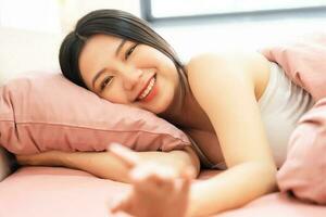Portrait of a beautiful and playful asian girl in bed in the morning photo