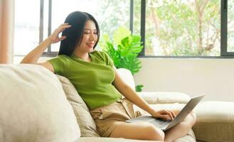 Portrait of a happy asian woman relaxing at home photo