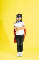 Portrait of little girl dressed up as a hero, isolated on yellow background photo