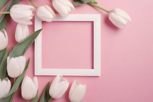 Empty white picture frame with pink tulips on a pink background photo