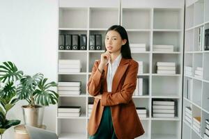 Young attractive Asian female office worker business suits smiling at camera in modern office photo