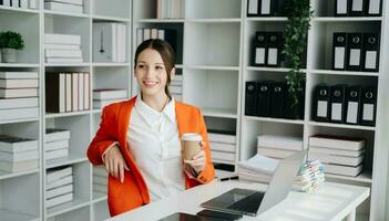 Beautiful Caucasian woman using laptop and tablet while sitting at her working place. Concentrated at work. photo