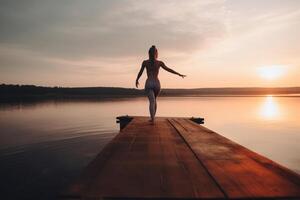 serenidad en movimiento mujer atractivo en puesta de sol yoga en lago muelle ai generado foto