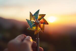 Toy Windmill in Hand Against a Beautiful Sunset photo