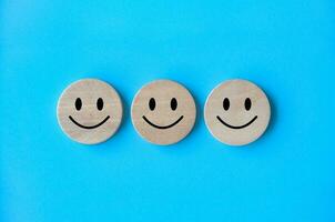 Happy emotion faces on wooden cubes. Customer satisfaction and evaluation concept. photo