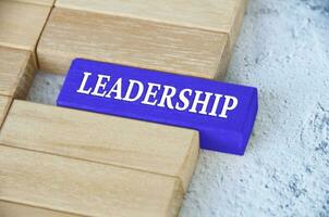 Leadership text on blue wooden block separated from the rest of the blocks. Leadership concept photo