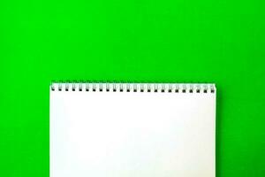 White notepad on a green background. photo