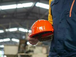 Orange color hand finger arm holding helmet safety labor employee staff hardhat person construction engineer industry occupation architect work job builder contractor profession tool copy space photo