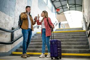 Adult couple missed the departure of the train. The are arguing at at the train station. photo