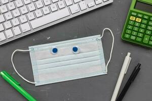 Mask, notebook and calculator. Tax return concept photo
