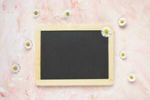 Empty message black board and fresh spring flowers photo