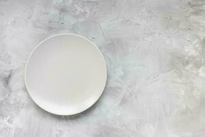 Empty plate on rough gray minimalistic background photo