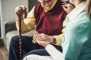 enfermero hogar cuidador es ayudando antiguo hombre a su hogar. profesional salud apoyo para mayor gente. foto
