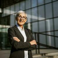 Outdoor portrait of successful mature businesswoman in front of company building. photo