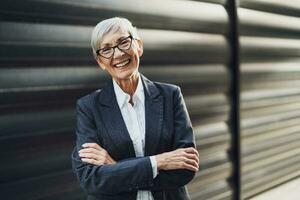 Outdoor portrait of successful mature businesswoman in front of company building. photo