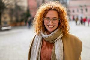 Natural portrait of smiling caucasian ginger woman with freckles and curly hair. photo