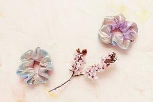 Shiny metallic scrunchie and fresh spring flowers photo