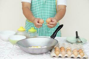 de cerca mano sostener huevos para Cocinando frito huevos menú en fritura cacerola. concepto, amor cocinando. rápido y fácil huevos menú. comida ingrediente. receta. cocina estilo de vida. asiático alimento. alto proteína foto