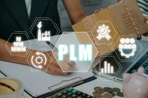 PLM - In industry, product lifecycle management concept, Person hand working on desk with PLM icon on virtual screen, program development, Technology, Internet and network. photo